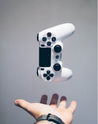 hand stretching outwards and a gaming controller floating over